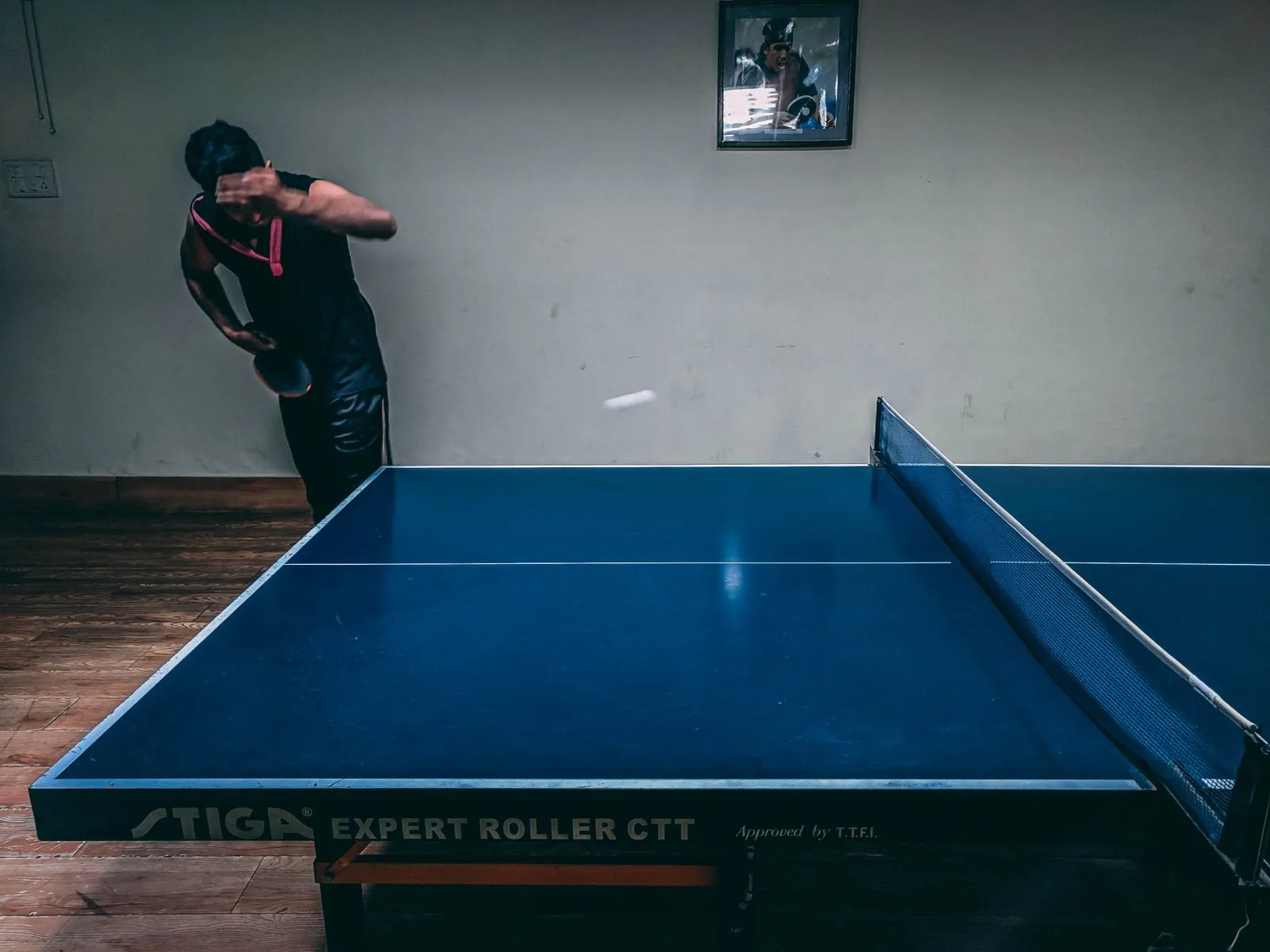 A player mid-rally at a table tennis table